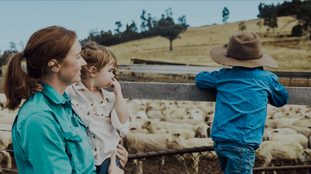 Woman with two children at a sheep yard representing generational involvement in farming and succession planning